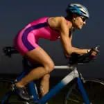 a woman in pink and purple riding a bike