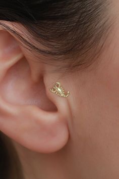 a close up of a person wearing a pair of ear piercings with diamonds on them