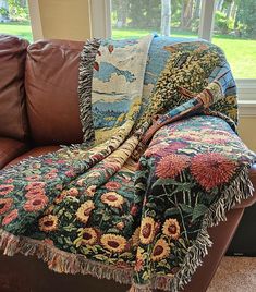 a couch with a blanket on it in front of a window