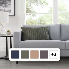 a living room with a gray couch and three pillows on it's side table