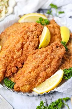 fried fish with lemons and parsley on a plate