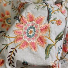 an embroidered pillow with colorful flowers on it