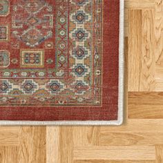 a red area rug on the floor with wood floors in the background and a wooden floor