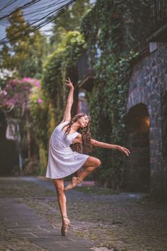 a young woman is dancing on the street