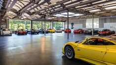 a large garage filled with lots of different colored sports cars in it's center