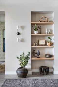 a living room filled with lots of furniture next to a wall mounted clock and potted plant