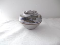 a white and blue vase sitting on top of a table next to a white wall