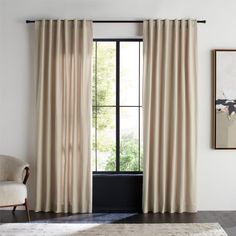 a living room with white walls and curtains