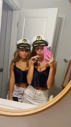 two beautiful young women in sailor hats taking a selfie