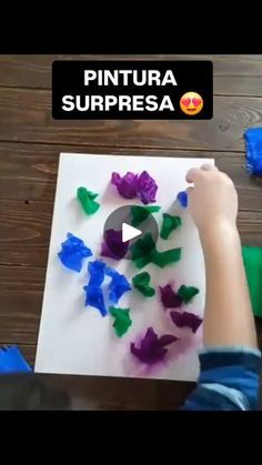 a young boy is making colorful paper butterflies on a piece of paper with the words pintura surpresa