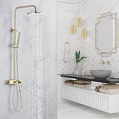 a white bathroom with gold fixtures and marble counter tops, along with a large shower head