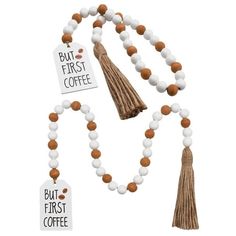 a white and brown tasseled necklace with two tags attached to the bead