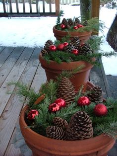 a christmas tree made out of pine cones and red baubles in a pot