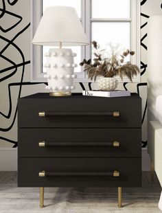 a black and white nightstand with a lamp next to it