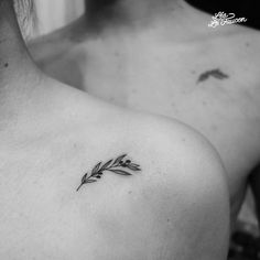 a black and white photo of a woman's chest with a small leaf tattoo on it