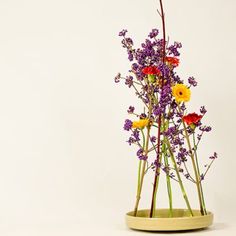 a vase filled with lots of flowers on top of a table