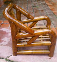 a chair made out of bamboo sitting on the ground in front of a brick walkway