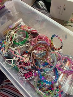 a plastic container filled with lots of assorted bracelets