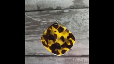 a yellow and brown necklace hanging from a silver chain