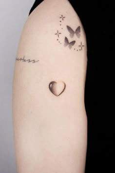 a woman with a tattoo on her arm has a heart and two butterflies in the shape of a clock