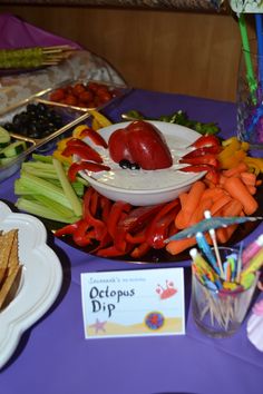 a table topped with lots of different types of vegetables and dips on top of plates