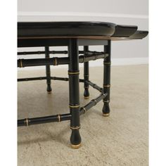 two black tables with gold trimmings on each end and one table has an oval top