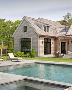 a house with a pool in front of it and an outdoor lounge area next to it