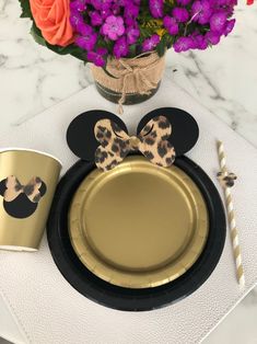 a mickey mouse plate and cup sitting on top of a table