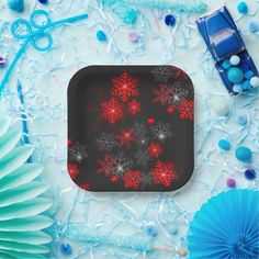 a black and red snowflake pattern on a square tray surrounded by blue decorations