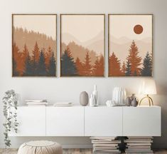 two paintings are hanging on the wall above a white cabinet in a modern living room