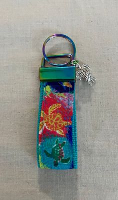 a keychain with a flowered design on it sitting on a white surface