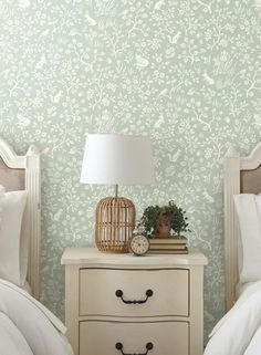 two white nightstands sitting next to each other on top of a wooden dresser in front of a green wall