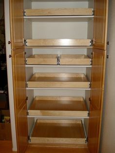 an empty closet with wooden shelves and drawers