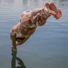 a man dives into the water to catch a frisbee