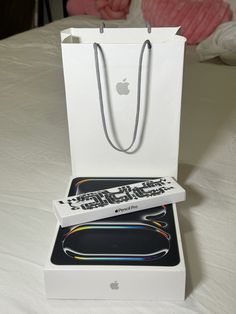 an apple product in a white box on top of a bed with the packaging open