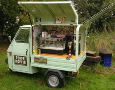 an old style coffee truck is parked in the grass