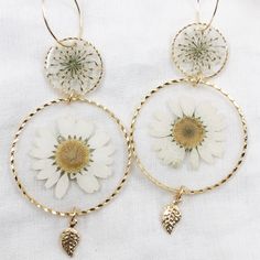 24k gold plated round dangle statement earrings made with real pressed flowers set in crystal clear resin. The small circle contains queen anne's lace, and the large circle contains a daisy. Perfect for nature lovers! These preserved botanical earrings are super lightweight and will make a statement! Pendants/charms: 24k gold plated brass Earring hoops: gold plated brass Follow us on Instagram at instagram.com/grabbagbotany to see our latest collection drops on our website, grabbagbotany.com. Th Delicate Gold Birth Flower Earrings, Delicate Adjustable Jewelry With Pressed Flowers, Botanical Jewelry With Pressed Flowers, Gold Flower-shaped Earrings With Pressed Flowers, Bohemian Birth Flower Drop Earrings, Gold Nickel-free Flower Earrings As Gift For Her, Dainty Flower Earrings With Birth Flower For Her, Gold Plated Flower Charm Earrings For Gift, Dainty Birth Flower Earrings As Gift For Her