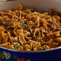 a pot filled with pasta and meat on top of a table