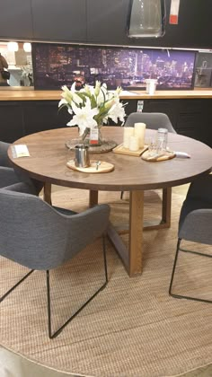 a round wooden table with chairs around it