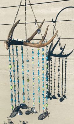 a deer antler with beads hanging from it's side on a wooden wall