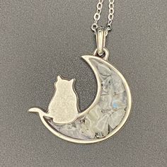 This stunning, silver-toned, cat & moon, open-bezel pendant features chips of genuine rainbow moonstone set in resin. Comes with a matching chain or black cotton cord.  Crystals & their meanings: Moonstone - Enhances intuition & connects to the Divine Feminine A donation will be made to the Eastern Pennsylvania Coalition for Abandoned Mine Reclamation (EPCAMR) for every purchase. Metal Jewelry With Cat Design, Metal Cat Design Round Jewelry, Silver Cat Design Round Necklace, Silver Cat Design Necklace, Adjustable Silver Necklace With Cat Design, Abandoned Mine, Harmony Ball, Cat Moon, The Divine Feminine