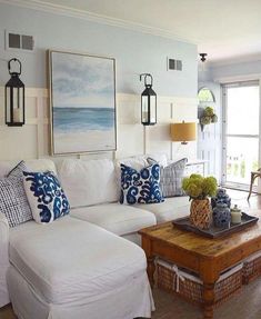 a living room filled with white furniture and lots of pillows on top of the couches