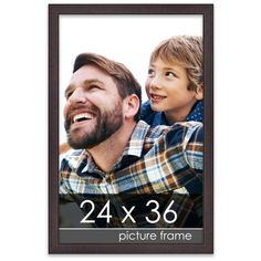 a man and boy are smiling for the camera with their picture frame in front of them