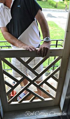 a man standing on a porch with his hand on the railing