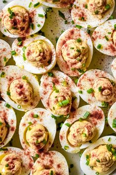 deviled eggs with mustard and chives on a white platter, ready to be eaten