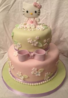 a hello kitty cake with flowers and bows on top