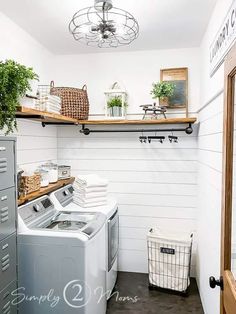 a washer and dryer sitting in a room next to a shelf filled with plants