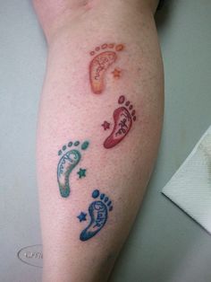 a person with tattoos on their legs and foot prints in the shape of stars, moon, and footprints