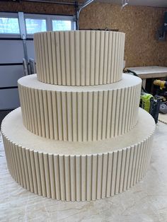 a three tiered cake sitting on top of a table next to a pair of scissors