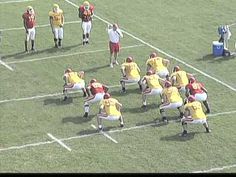 a group of football players standing on top of a field